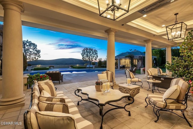 patio terrace at dusk with ceiling fan and a mountain view