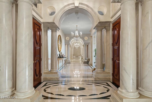 hall with a chandelier and decorative columns