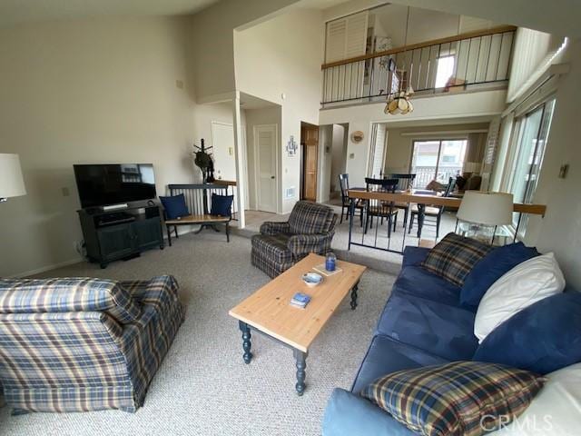 living room with a towering ceiling and light colored carpet