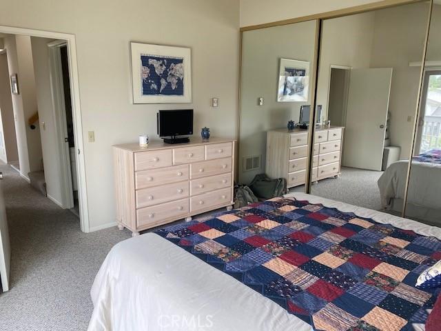 bedroom with light carpet and a closet