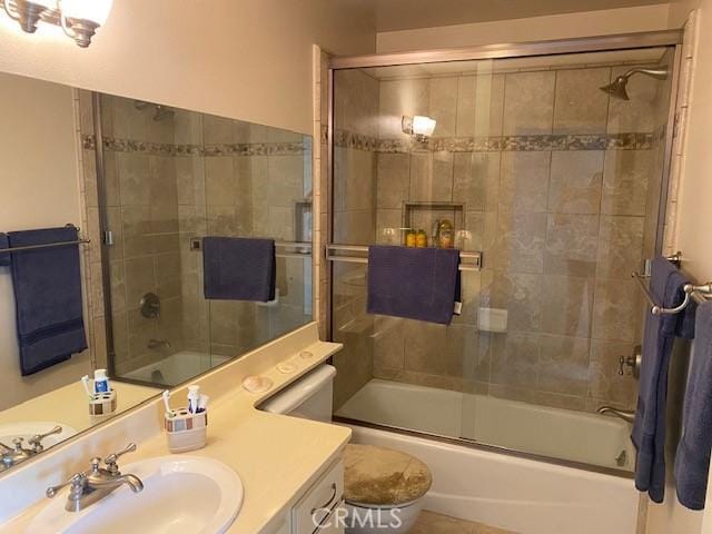 full bathroom featuring bath / shower combo with glass door, vanity, and toilet