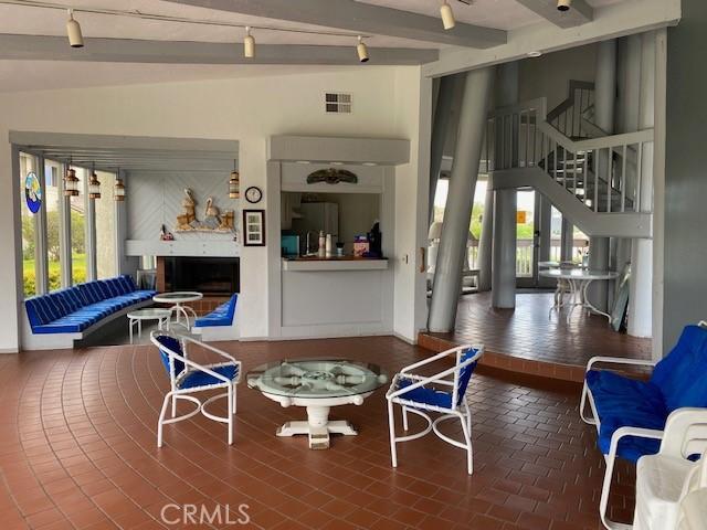 interior space featuring lofted ceiling with beams and rail lighting