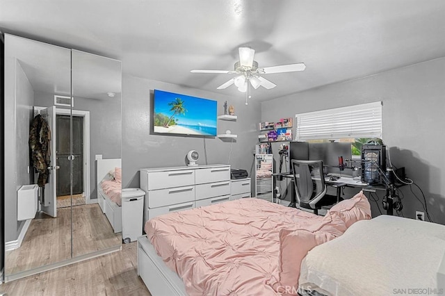 bedroom with ceiling fan, radiator heating unit, and light hardwood / wood-style flooring