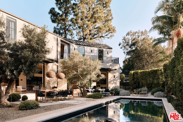 exterior space with an outdoor living space, a balcony, and a patio area