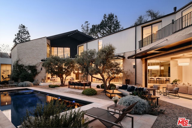 view of swimming pool with an outdoor living space and a patio