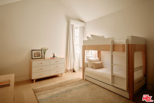 bedroom with lofted ceiling and light hardwood / wood-style floors