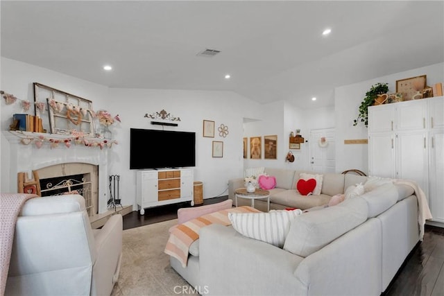 living room featuring vaulted ceiling, wood-type flooring, and a high end fireplace