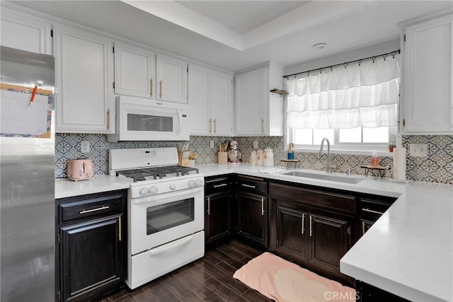 kitchen featuring white appliances, sink, decorative backsplash, and white cabinets