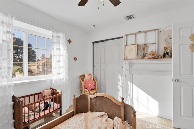 bedroom with light tile patterned flooring, ceiling fan, and a closet