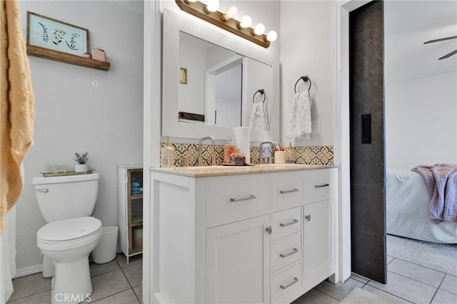 bathroom with tile patterned flooring, vanity, backsplash, and toilet