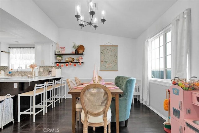 dining area featuring dark wood-type flooring and a chandelier