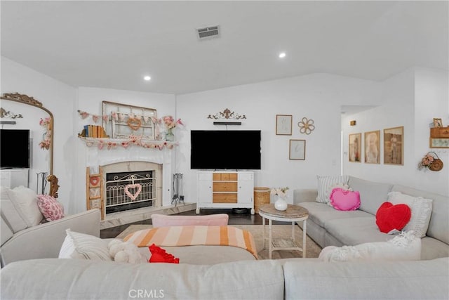 living room with a high end fireplace and vaulted ceiling