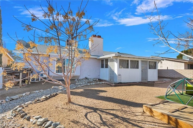 rear view of property featuring a sunroom