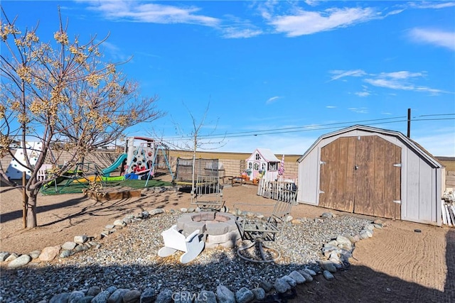 view of yard with a storage shed, a fire pit, and a playground