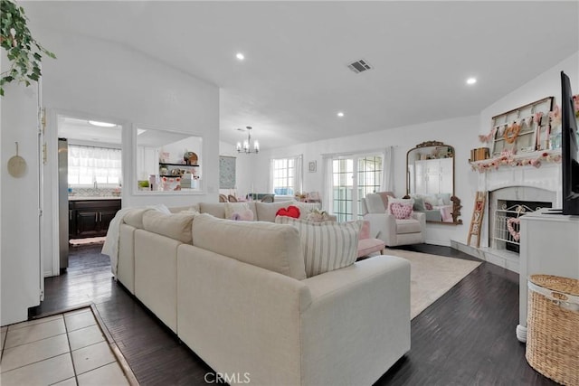 living room with dark wood-type flooring, sink, and an inviting chandelier