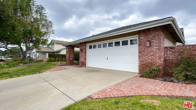 ranch-style house with a garage and a front lawn