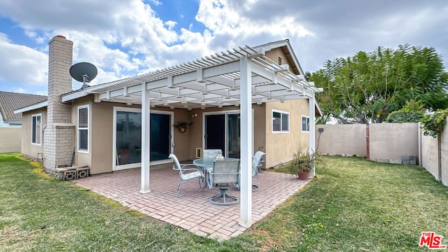 rear view of property featuring a yard, a pergola, and a patio