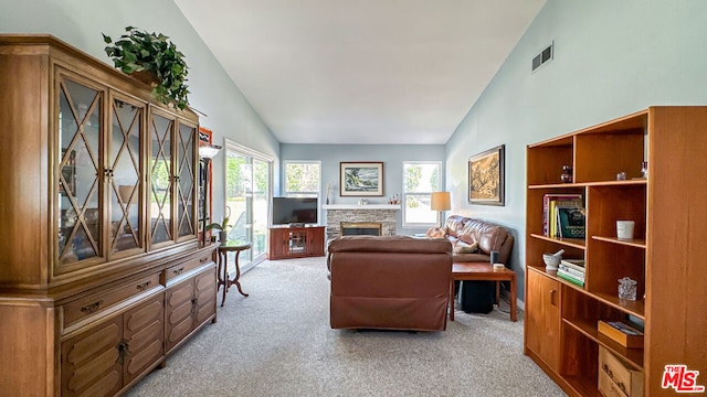 carpeted living room featuring high vaulted ceiling and a fireplace