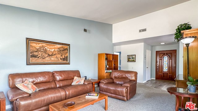 carpeted living room with a high ceiling