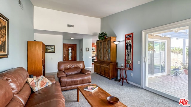 living room featuring a high ceiling and light carpet