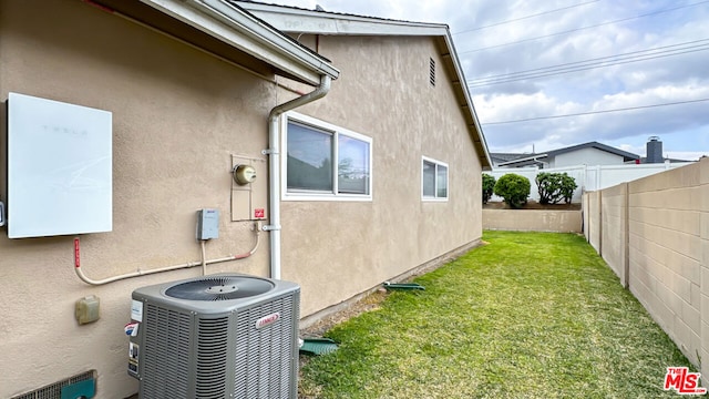 view of home's exterior featuring a yard and central AC