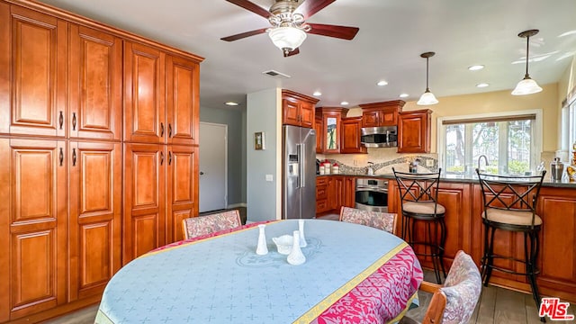 dining area featuring sink, light hardwood / wood-style floors, and ceiling fan