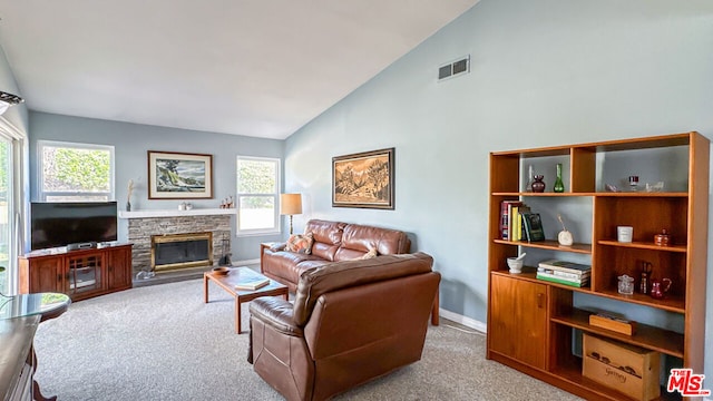 carpeted living room with a fireplace and high vaulted ceiling