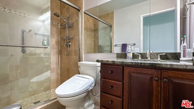 bathroom featuring vanity, toilet, and a shower with shower door