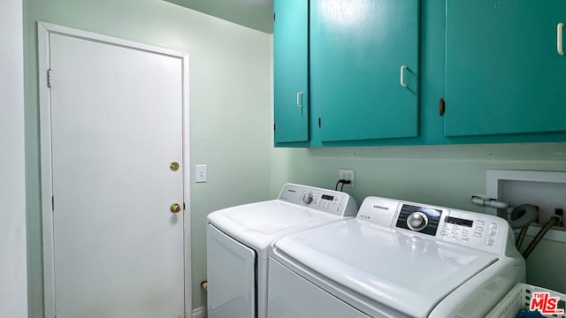 laundry room with washer and clothes dryer and cabinets