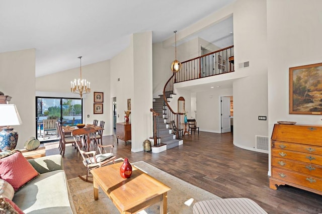 living room with high vaulted ceiling, an inviting chandelier, and dark hardwood / wood-style flooring