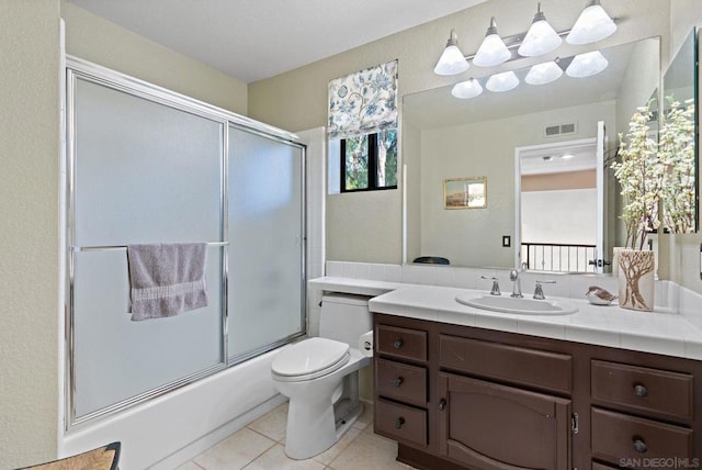 full bathroom with tile patterned flooring, bath / shower combo with glass door, vanity, and toilet