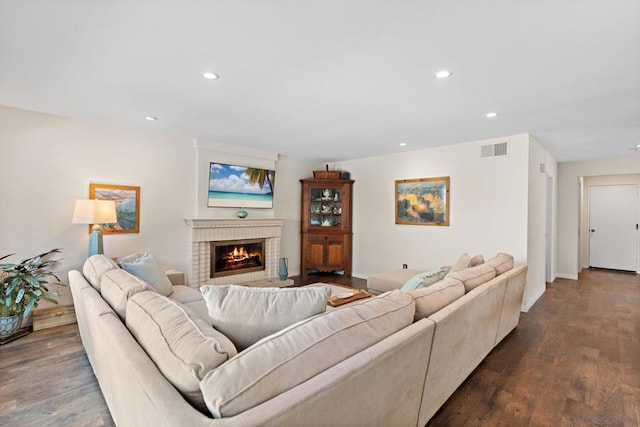 living room with dark wood-type flooring and a fireplace