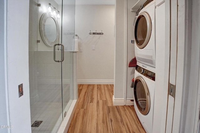 washroom with stacked washing maching and dryer and light wood-type flooring