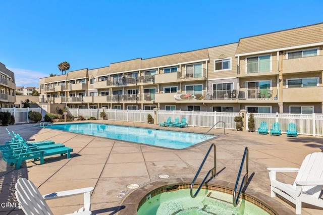 view of swimming pool with a hot tub