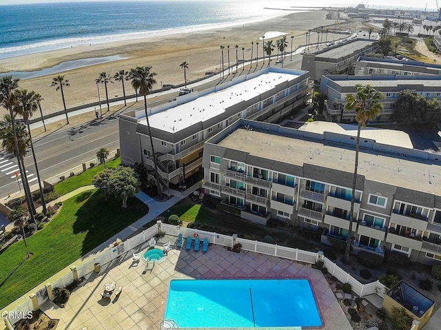 birds eye view of property with a water view and a beach view