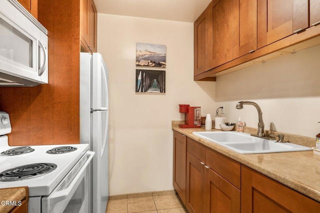 kitchen featuring sink, light tile patterned floors, and white appliances