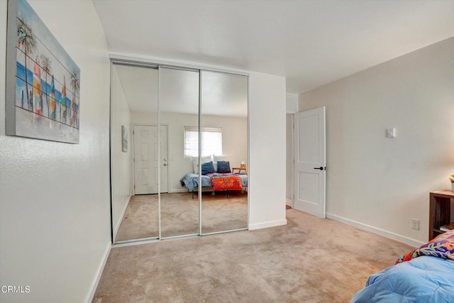 bedroom with light colored carpet and a closet