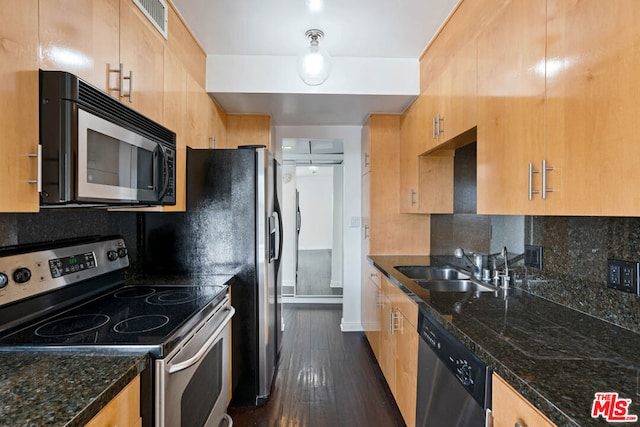 kitchen with tasteful backsplash, stainless steel appliances, sink, and dark stone countertops