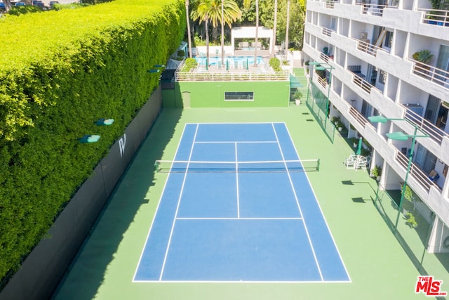 view of tennis court with a community pool