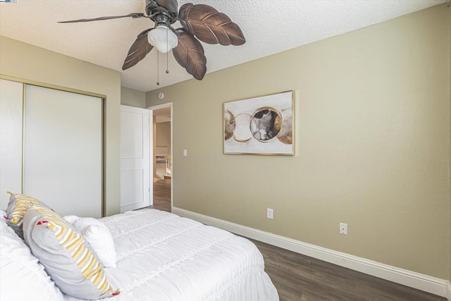 bedroom featuring dark wood-type flooring, ceiling fan, a closet, and a textured ceiling