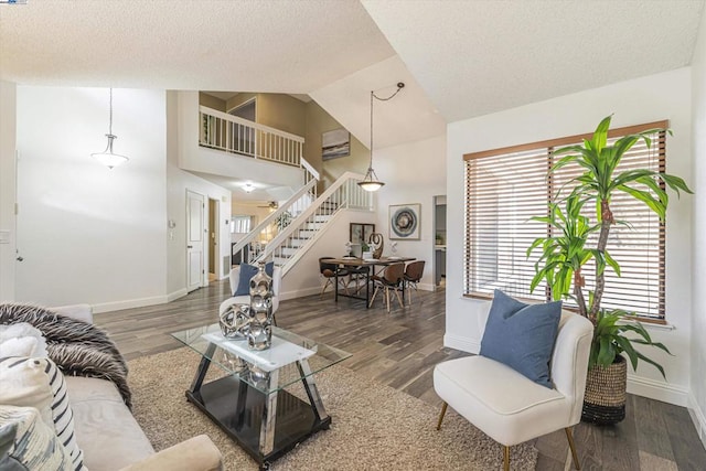 living room with dark hardwood / wood-style floors, high vaulted ceiling, and a textured ceiling