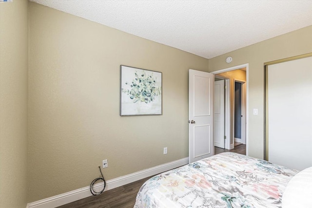 bedroom with dark wood-type flooring and a textured ceiling