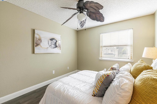 bedroom with dark hardwood / wood-style flooring, ceiling fan, and a textured ceiling