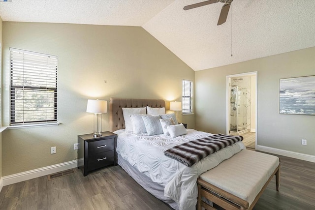 bedroom with ensuite bathroom, lofted ceiling, dark hardwood / wood-style floors, and a textured ceiling