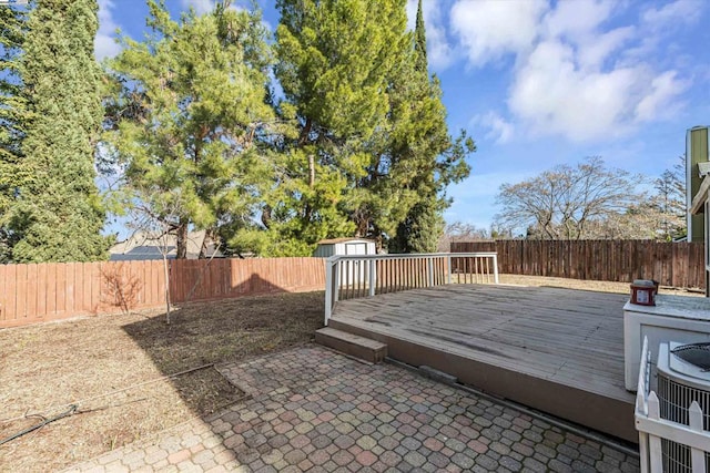 wooden deck featuring a shed, central AC, and a patio