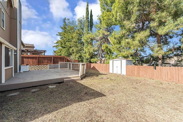 view of yard featuring a wooden deck and a shed