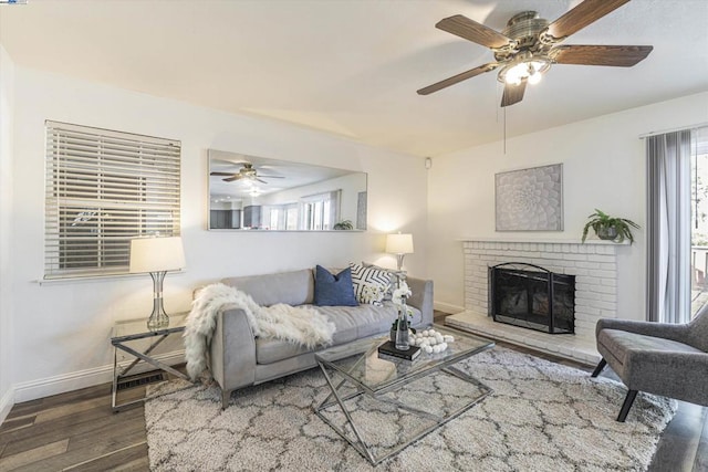 living room featuring a brick fireplace, dark hardwood / wood-style floors, ceiling fan, and plenty of natural light