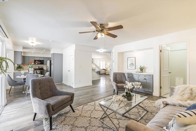 living room featuring ceiling fan and light hardwood / wood-style flooring