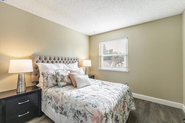 bedroom with dark wood-type flooring and a textured ceiling