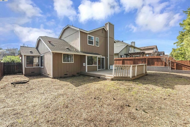 back of property with a wooden deck and a yard